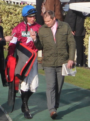 jockey carrying saddle and blanket