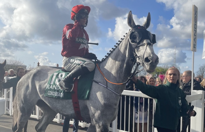 grey horse with jockey and blinker hood