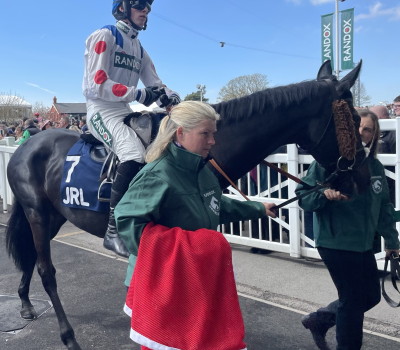 stable hand holding horse jacket at Aintree
